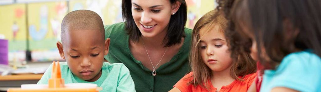 A childcare provider sitting with children
