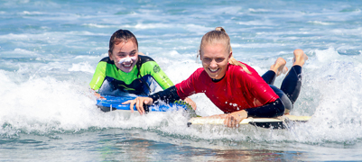 Photo of of a Surf Camp Surfer with an instructor in the water