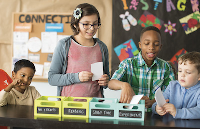 Photo of four YMCA children holding note cards