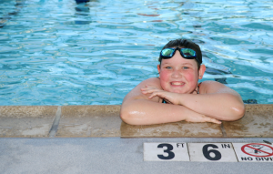 Chica nadando en la piscina sonriendo