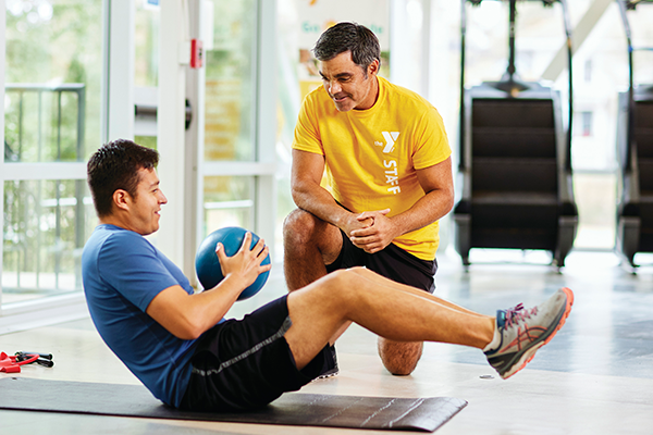 Photo of a member doing ab twists with a medicine ball