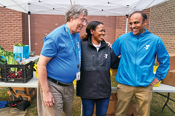 Photo of three adults, smiling.