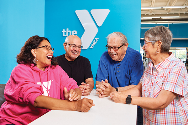 Photo of four adults sitting together at a table at the YMCA