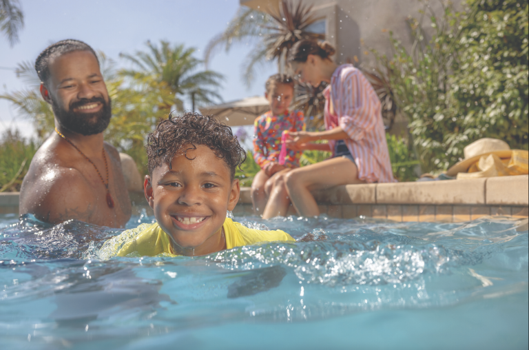 child swimming in water with parents