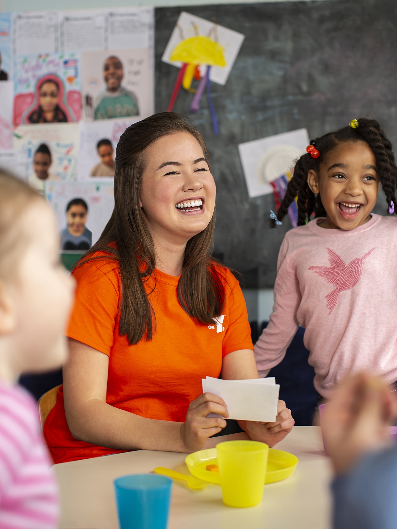 staff person doing crafts with kids in child care setting