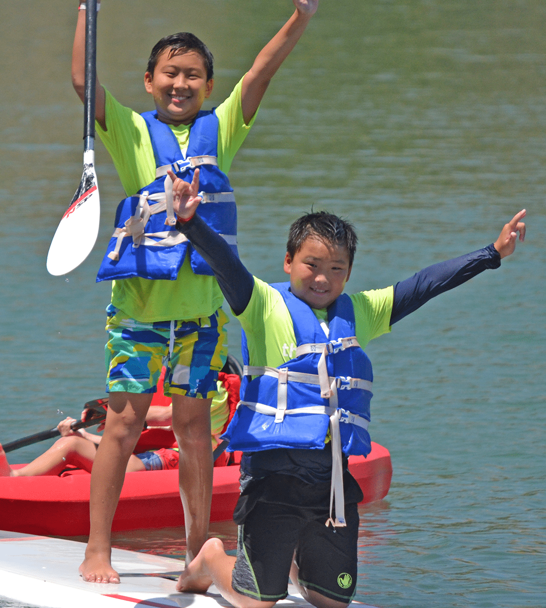 two boys on paddleboard at camp
